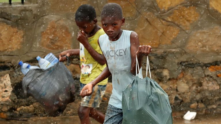 Des enfants marchent dans des rues inondées alors que la pluie tombait après le cyclone Kenneth à Pemba, au Mozambique, le 30 avril 2019. REUTERS / Mike Hutchings