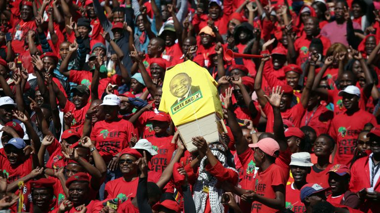 Les partisans du parti d'opposition Economic Freedom Fighters tiennent un faux cercueil portant le visage du président au pouvoir