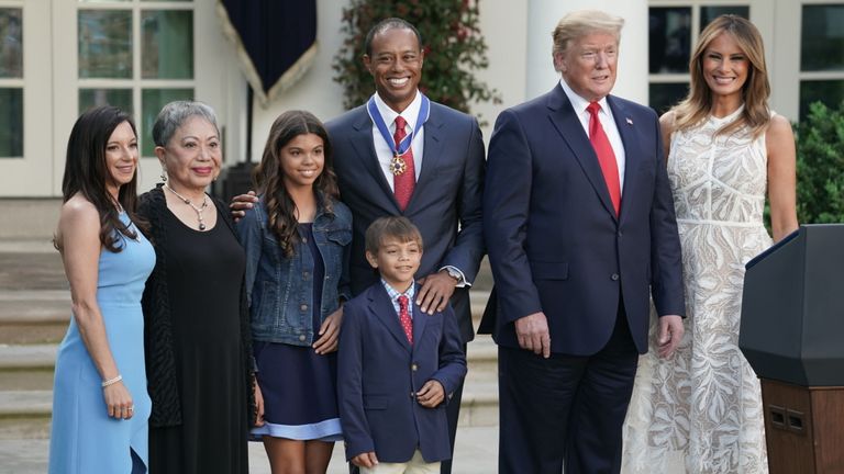 Donald et Melania Trump (à droite) posent avec Tiger Woods (au centre) et sa famille lors de la cérémonie au jardin des roses