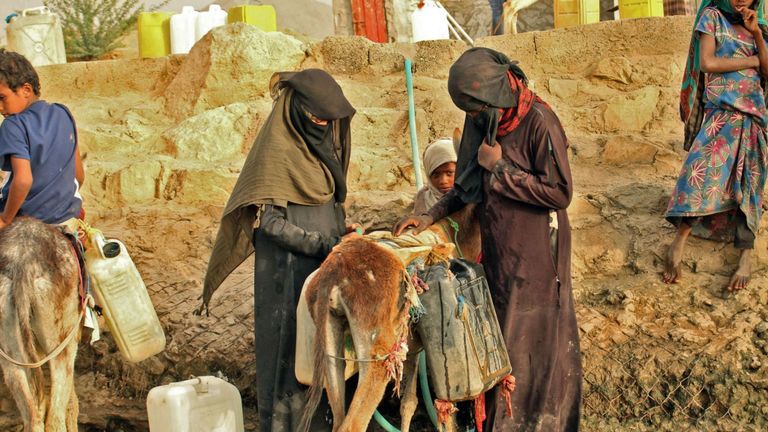Des Yéménites déplacés d'Hodeida remplissent des bidons d'eau dans un camp de fortune