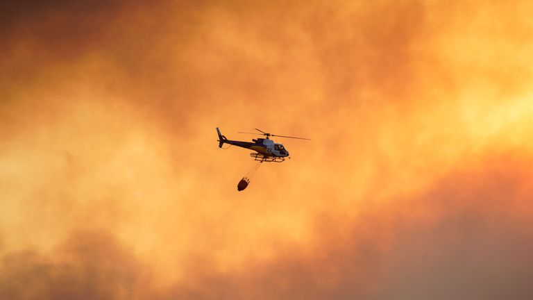 Un hélicoptère survole un feu de forêt près de la ville de Tolède, en Espagne. 