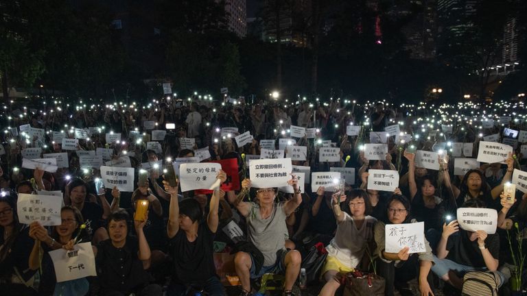 HONG KONG - 14 juin: Les gens brandissent des lumières de smartphone et des affiches pendant une 