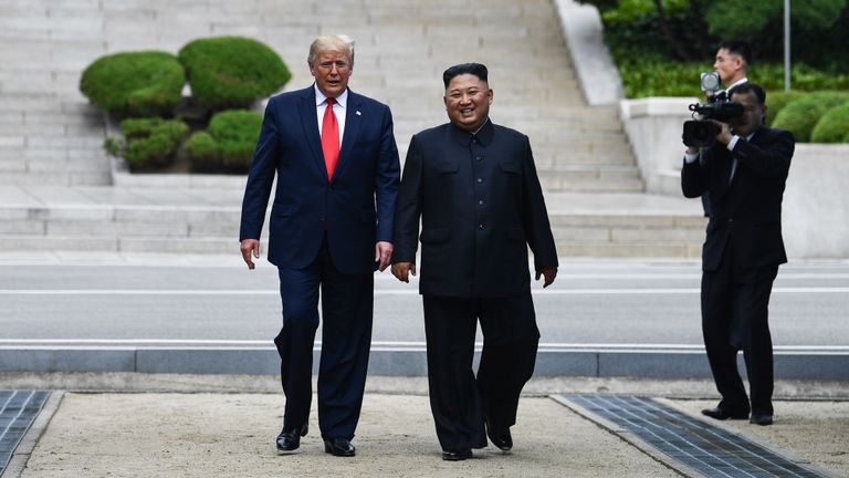 La dirigeante nord-coréenne Kim Jong Un se promène avec le président américain Donald Trump au nord de la ligne de démarcation militaire qui sépare la Corée du Nord et la Corée du Sud, dans la zone de sécurité commune de Panmunjom dans la zone démilitarisée (DMZ) le 30 juin 2019. (Photo de Brendan Smialowski / AFP) (Le crédit photo doit se lire comme suit: BRENDAN SMIALOWSKI / AFP / Getty Images)