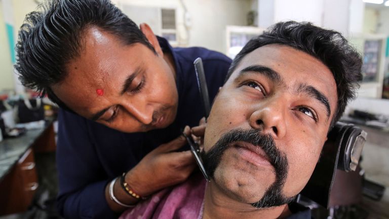 Un homme recevant un & # 39; Abhinandan & # 39; dans un salon de coiffure à Ahmedabad