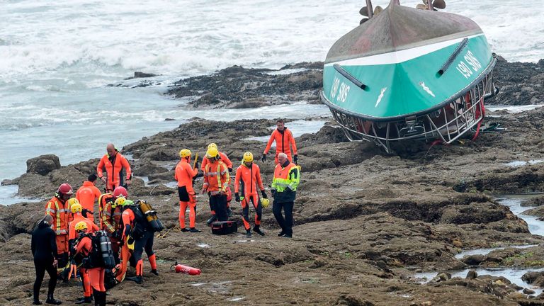 Les sauveteurs travaillent près du bateau chaviré