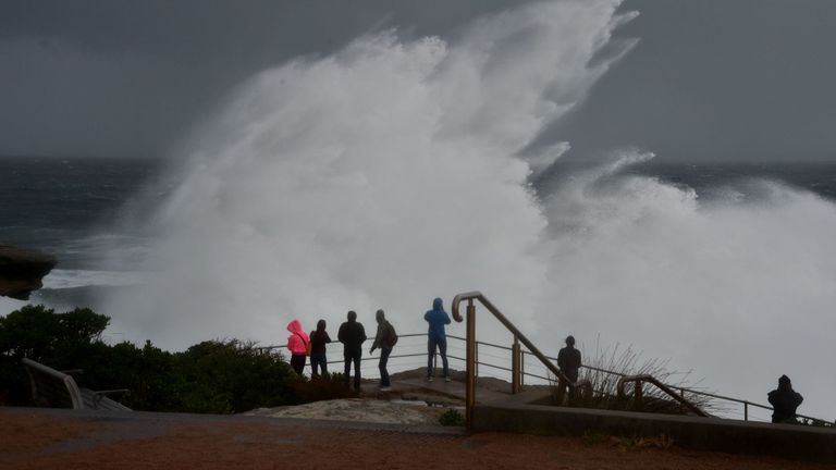 Les visiteurs observent d'énormes vagues se briser sur les rochers sur la plage nord de Bondi, alors qu'une tempête hivernale s'abat sur Sydney le 4 juin 2019.