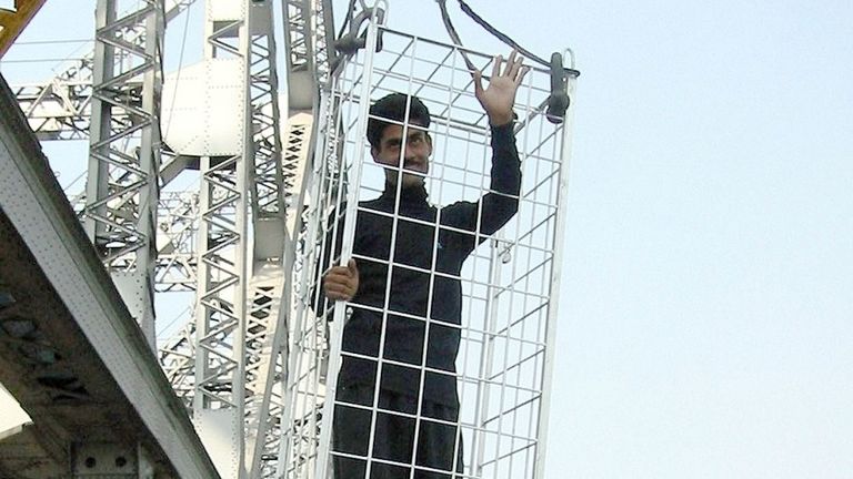 L'artiste indien en fuite Chanchal Lahiri, évadé en cage, salue la foule avant d'être descendu dans la rivière Hooghly en 2002.