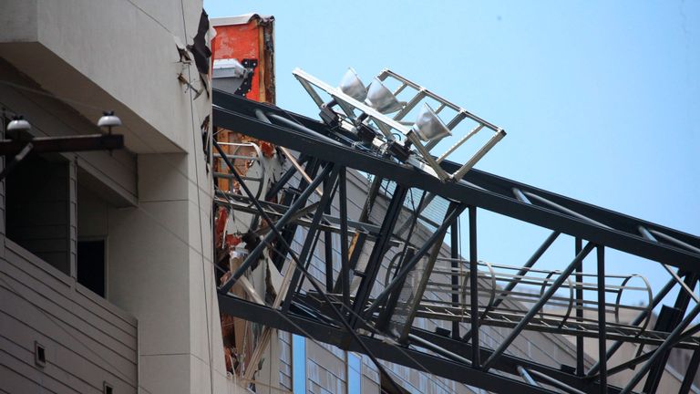 Des fonctionnaires réagissent à la scène après qu'une grue se soit effondrée dans les appartements d'Elan City Lights au milieu d'orages violents