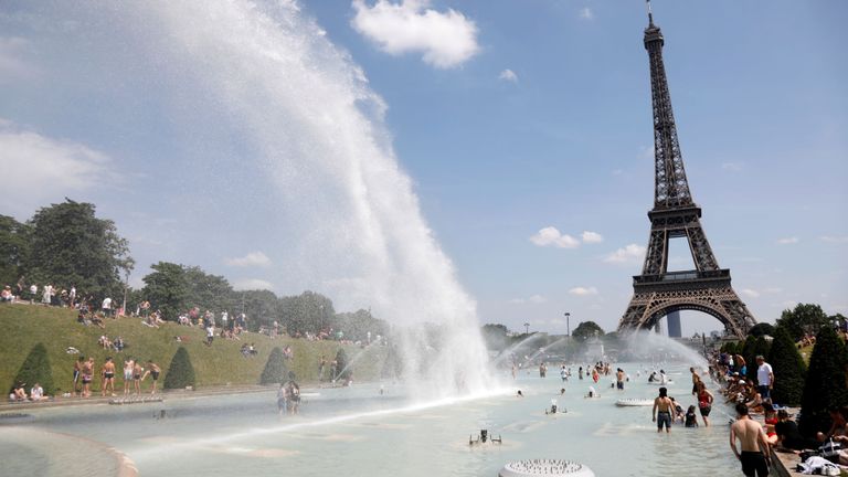 Les gens se calment dans les fontaines du Trocadéro en face de la Tour Eiffel à Paris alors qu'une vague de chaleur frappe une grande partie du pays