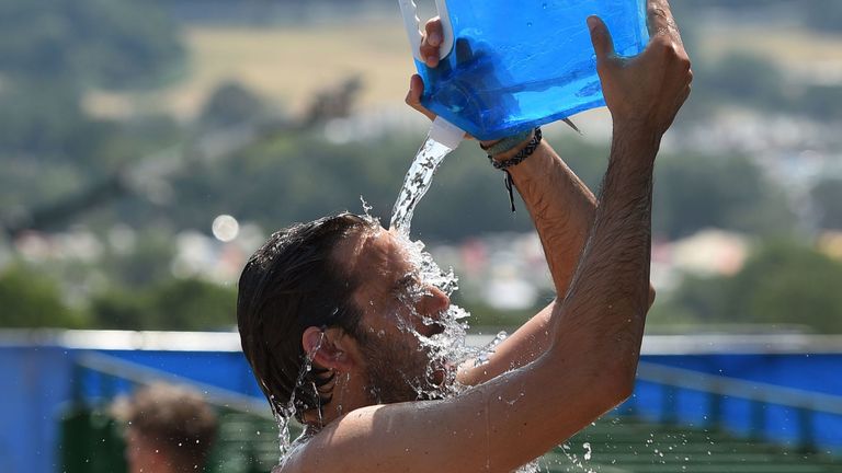 Un fan de musique essaie de rester au frais en se aspergeant d'eau