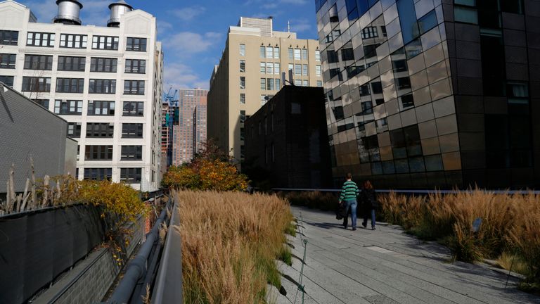 Les gens marchent le long du parc High Line sur une chaude journée d'automne à New York