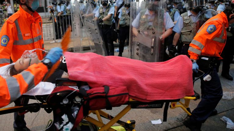 Un manifestant est porté sur une civière par des ambulanciers paramédicaux