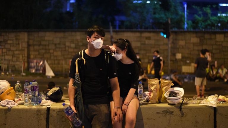 TOPSHOT - Les manifestants se reposent la nuit après une manifestation contre une proposition de loi controversée sur l’extradition à Hong Kong le 12 juin 2019. - De violents affrontements ont éclaté à Hong Kong le 12 juin alors que la police tentait d’empêcher les manifestants de prendre d'assaut la ville. Parlement, alors que des dizaines de milliers de personnes ont bloqué des artères clés lors d'une manifestation de force contre les projets du gouvernement d'autoriser les extraditions vers la Chine. (Photo par HECTOR RETAMAL / AFP) (Le crédit photo doit correspondre à HECTOR RETAMAL / AFP / Getty Images)