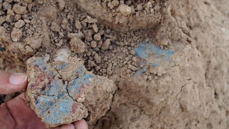Un fragment de mur montrant une peinture murale avec de la peinture bleue et rouge. Pic: IANES