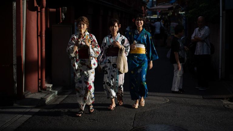 Des femmes portant des kimonos marchent dans une rue du quartier Asakusa de Tokyo