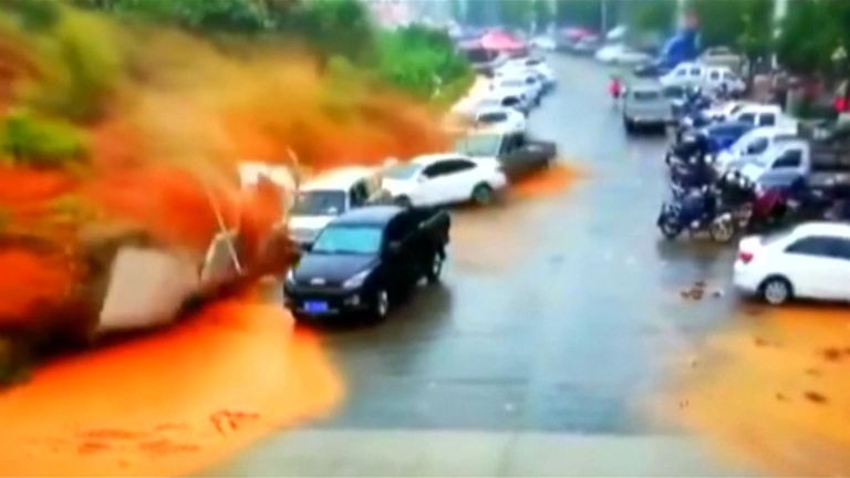 Un glissement de terrain a avalé des voitures et piégé un homme dans sa voiture, alors que les secouristes tentaient de le dégager. Sa situation reste inconnue.