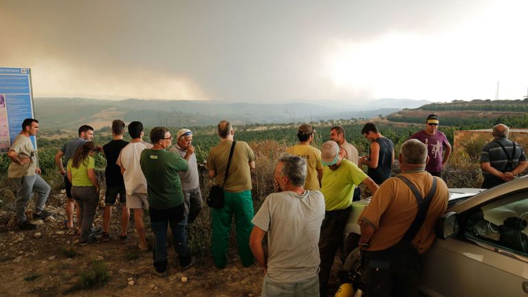 Les habitants se rassemblent pour observer un incendie de forêt qui fait rage près de Maials dans la région nord-est de la Catalogne le 27 juin 2019. - Un incendie de forêt espagnol a fait rage de s'embraser sous une vague de chaleur européenne dévastant des centaines de pompiers dans la nuit, ont déclaré les autorités locales . (Photo de Pau Barrena / AFP) (Le crédit photo devrait correspondre à PAU BARRENA / AFP / Getty Images)