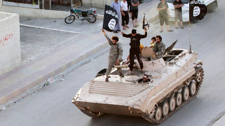 Des combattants de l'État islamique participent à un défilé militaire dans la province de Raqqa en juin 2014