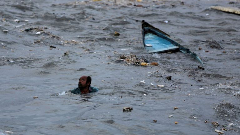 Un pêcheur nage vers le rivage après que son bateau a chaviré à cause d'une forte houle