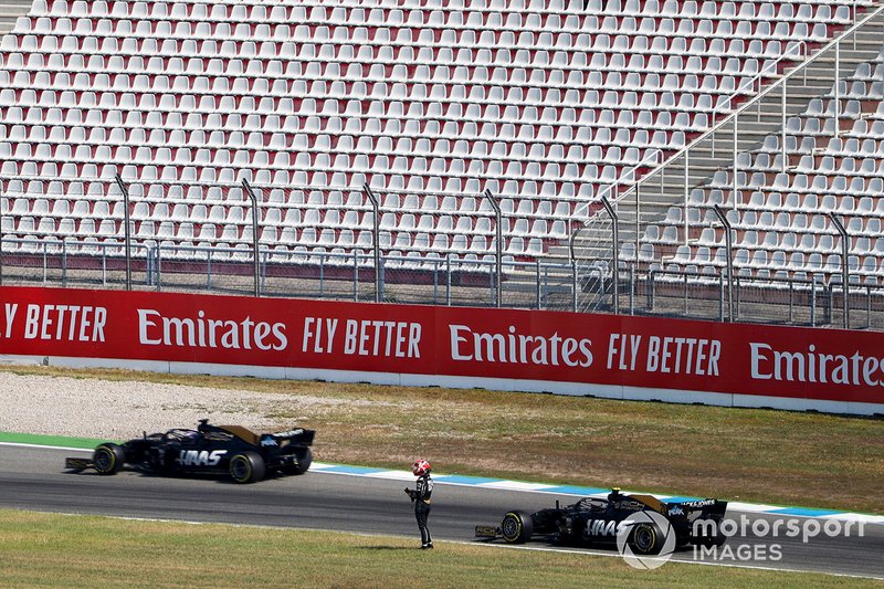 Romain Grosjean, Haas F1 Team VF-19, passe devant la voiture arrêtée de Kevin Magnussen, Haas F1 Team VF-19