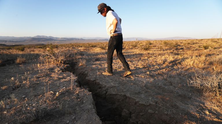 Ridgecrest, Californie - 4 juillet: un résident local inspecte une fissure dans la terre après qu'un séisme de magnitude 6,4 a frappé la région le 4 juillet 2019 près de Ridgecrest, en Californie. Le séisme a été le plus important qui ait frappé le sud de la Californie en 20 ans avec l'épicentre situé dans une région reculée du désert de Mojave. Les résidents de la majeure partie du sud de la Californie ont ressenti le tremblement de terre. (Photo de Mario Tama / Getty Images)