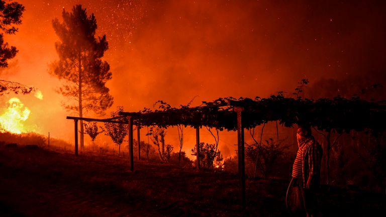 Un village tient un tuyau alors qu'un feu de forêt s'approche de son domicile à Amendoa, le 21 juillet 2019, dans le centre du Portugal. Plus d'un millier de pompiers se sont battus pour maîtriser les incendies dans le centre du Portugal qui ont contraint des évacuations de village, dans une région où Les pompiers ont été mobilisés pour lutter contre trois incendies dans la région montagneuse et fortement boisée de Castelo Branco, à 200 km au nord de Lisbonne, selon le site internet de la Protection civile. (Photo de PATRICIA DE MELO MOREIRA / AFP) (Le crédit photo devrait se lire PATRICIA DE MELO MOREIRA / AFP / Getty Images)