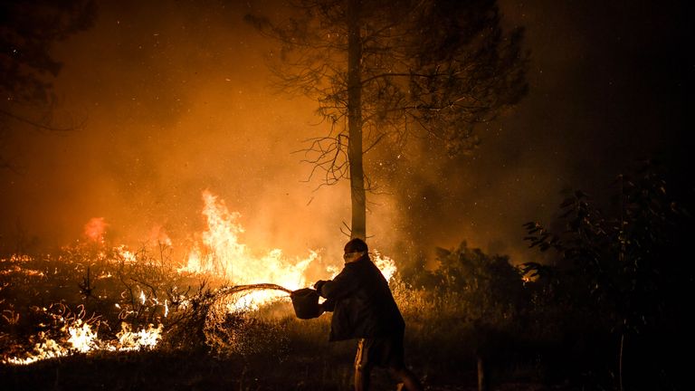 Le 21 juillet 2019, un villageois tente d'éteindre l'incendie qui approche près de son domicile à Amendoa à Macao, dans le centre du Portugal. - Plus d'un millier de pompiers se sont battus pour maîtriser les incendies dans le centre du Portugal qui ont contraint des évacuations de village, dans une région Les pompiers ont été déployés pour lutter contre trois incendies dans la région montagneuse et fortement boisée de Castelo Branco, à 200 km au nord de Lisbonne, selon le site internet de la Protection civile. (Photo de PATRICIA DE MELO MOREIRA / AFP) (Le crédit photo devrait se lire PATRICIA DE MELO MOREIRA / AFP / Getty Images)