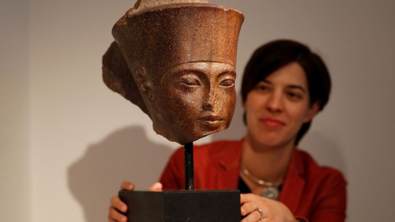 Laetitia Delaloye, responsable des antiquités de Christie, pose pour une photo avec une tête de Toutankhamen en quartzite marron égyptien avant sa vente à la maison de vente aux enchères Christie à Londres jeudi