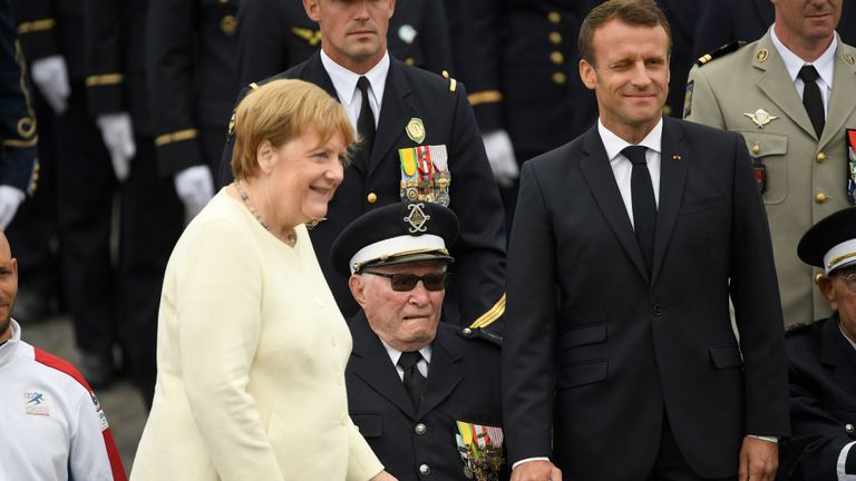 Emmanuel Macron et Angela Merkel aux côtés d'un ancien combattant de la Seconde Guerre mondiale lors du défilé
