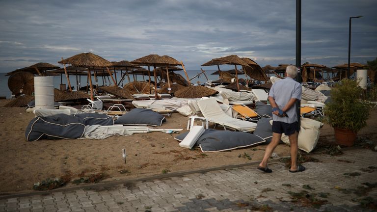 Un homme regarde des parasols et des chaises longues endommagés à la suite de violents orages sur la plage du village de Nea Plagia, en Grèce, le 11 juillet 2019. REUTERS / Alkis Konstantinidis