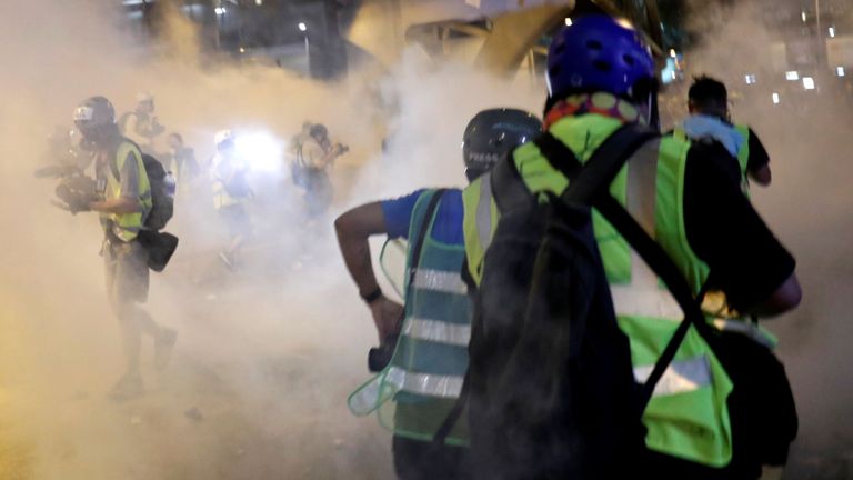 Les gens fuient après le tir de gaz lacrymogène dans la foule