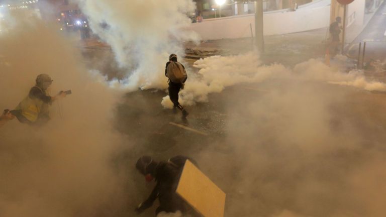 Des manifestants courent après que des gaz lacrymogènes ont été tirés par la police