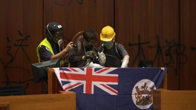 Les manifestants accrochent le vieux drapeau de Hong Kong - arborant le drapeau de l'union - à la chambre du parlement.