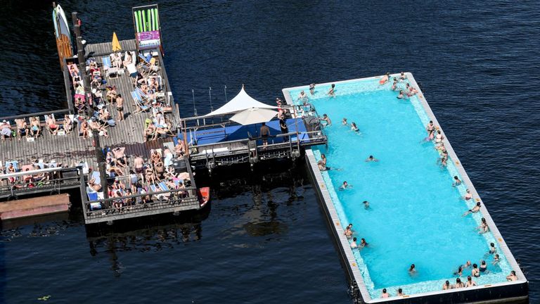 Les gens se rafraîchir dans la piscine publique "Badeschiff" (bateau piscine) sur la rivière Spree dans le centre de Berlin
