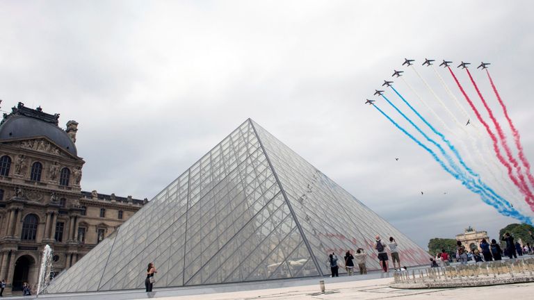 Les jets volent dans le ciel au-dessus du musée du Louvre à Paris