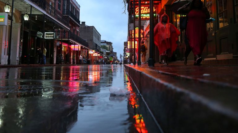 Les touristes marchent sur la rue Bourbon lors de l’ouragan Barry à la Nouvelle-Orléans, Louisiane, États-Unis, le 13 juillet 2019