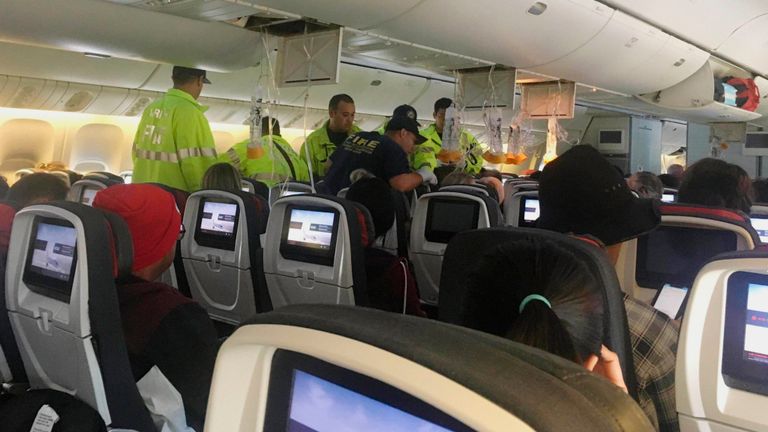 Les intervenants traitent un passager d'un vol d'Air Canada à destination d'Australie qui a été dérouté et atterri à l'aéroport international Daniel K. Inouye à Honolulu 