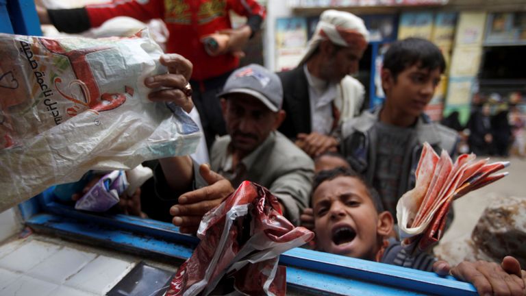Des garçons font la queue pour obtenir du pain dans une boulangerie de charité à Sanaa, capitale du Yémen