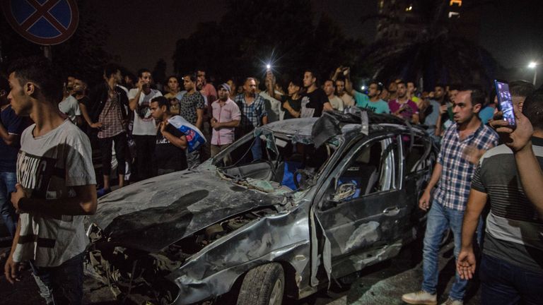 Les spectateurs se rassemblent autour d'une voiture carbonisée à la suite d'un accident survenu juste avant minuit le 4 août 2019 devant l'Institut national du cancer dans la capitale égyptienne, Le Caire. - Au moins 19 personnes ont été tuées et plus de 30 blessées lorsqu'un véhicule roulant à grande vitesse a heurté trois autres personnes, provoquant une énorme explosion dans la capitale, a annoncé aujourd'hui le ministère égyptien de la Santé. (Photo de Aly FAHIM / AFP) (Le crédit photo devrait correspondre à ALY FAHIM / AFP / Getty Images)
