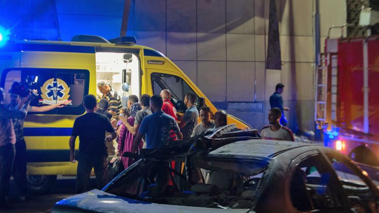 Les gens se rassemblent près d'une ambulance dans la nuit du 5 août 2019, sur les lieux d'un accident survenu peu avant minuit le 4 août, devant l'Institut national du cancer du Caire, dans la capitale égyptienne. - Au moins 19 personnes ont été tuées et plus de 30 blessées lorsqu'un véhicule roulant à grande vitesse a heurté trois autres personnes, provoquant une énorme explosion dans la capitale, a annoncé aujourd'hui le ministère égyptien de la Santé. (Photo de Aly FAHIM / AFP) (Le crédit photo devrait correspondre à ALY FAHIM / AFP / Getty Images)