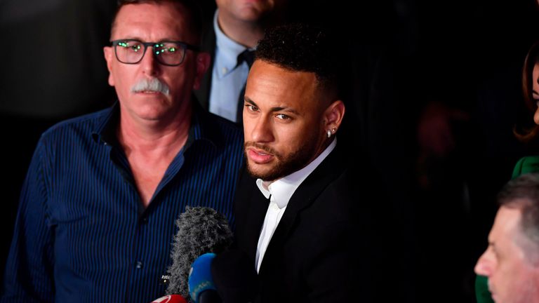 Le 13 juin 2019, le footballeur brésilien Neymar (C) s'entretient avec des journalistes alors qu'il partait en béquilles dans l'enceinte de la défense des femmes à Sao Paulo, au Brésil. Après avoir témoigné devant le Brésilien Najila Trindade, il avait porté plainte le 31 mai 2019. il l'a agressée après l'avoir invitée à lui rendre visite à Paris. - La police brésilienne a annoncé jeudi qu'elle avait intenté un procès en diffamation contre la femme qui avait accusé la star du football Neymar de viol, après avoir insinué que la force était corrompue. (Photo de Nelson Almeida / AFP) (Le crédit photo doit correspondre à: NELSON ALMEIDA / AFP / Getty Images)