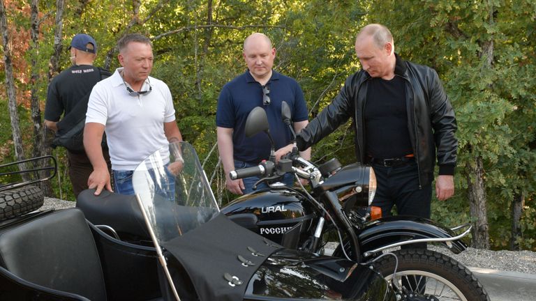 Le président russe Vladimir Poutine se tient à côté d'une moto de l'Oural lors d'un salon organisé par un club de motards 