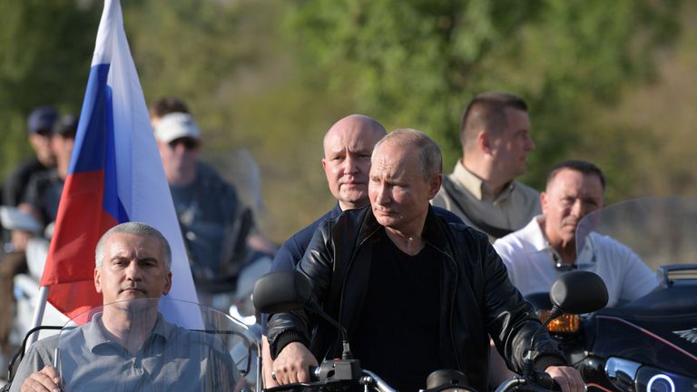 Le président russe Vladimir Poutine, le gouverneur par intérim de Sébastopol Mikhaïl Razvozhayev et le chef de la Crimée Sergueï Aksyonov conduisent une moto de l'Oural pour participer à un spectacle organisé par un club de motards 