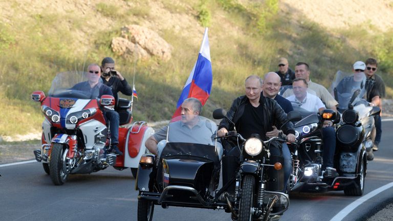 Le président russe Vladimir Poutine, le gouverneur par intérim de Sébastopol Mikhaïl Razvozhayev et le chef de la Crimée Sergueï Aksyonov conduisent une moto de l'Oural pour participer à un spectacle organisé par un club de motards 