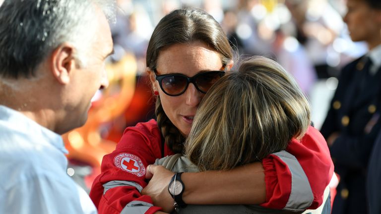 Un membre de la Croix-Rouge embrasse un membre de sa famille avant la messe pour le premier anniversaire de l'effondrement du pont de Morandi, le 14 août 2019 à Gênes. (Photo par Alberto PIZZOLI / AFP) (Le crédit photo devrait se lire ALBERTO PIZZOLI / AFP / Getty Images)