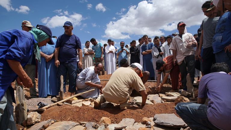 Les gens creusent une tombe en enterrant les victimes des inondations lorsqu'un fleuve a éclaté sur ses rives et inondé un terrain de football de village où se jouait un match, dans le village de Tizert, dans le sud du Maroc, dans la région de Taroudant, le 29 août 2019. - Les victimes incluses un garçon de 17 ans et six hommes âgés assistant au match dans le village de Tizert, dans la région de Taroudant. Les chercheurs ont sauvé un homme blessé par l'inondation et à la recherche d'une autre personne disparue, ont indiqué des responsables. La rivière a débordé et a submergé le terrain où se déroulait un tournoi de football amateur, a déclaré un habitant à l'AFP. (Photo by - / AFP) (Le crédit photo devrait se lire - / AFP / Getty Images)