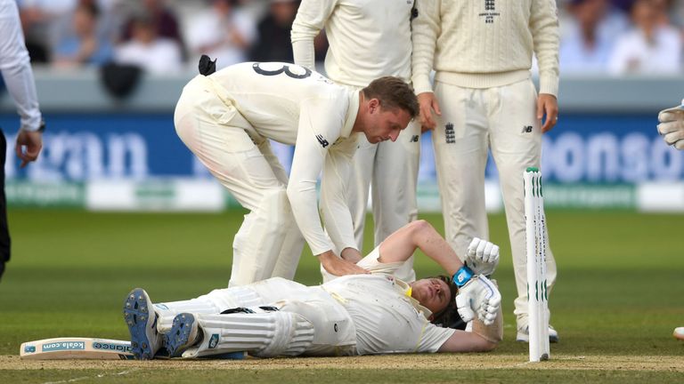 Jos Buttler, Jack Leech et Joe Root, d’Angleterre, regardent Steven Smith, d’Australie, allongé au sol après avoir été touché à la tête par un ballon de Jofra Archer, d’Angleterre, lors de la quatrième journée du deuxième match du Specsavers Ashes Test chez Lord & # 39 ; s Terrain de cricket le 17 août 2019 à Londres, Angleterre