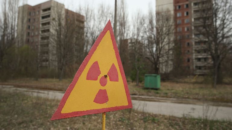 Un panneau avertit de la contamination radioactive à proximité d'anciens immeubles d'habitation abandonnés à l'intérieur de la zone d'exclusion de Pripyat, en Ukraine