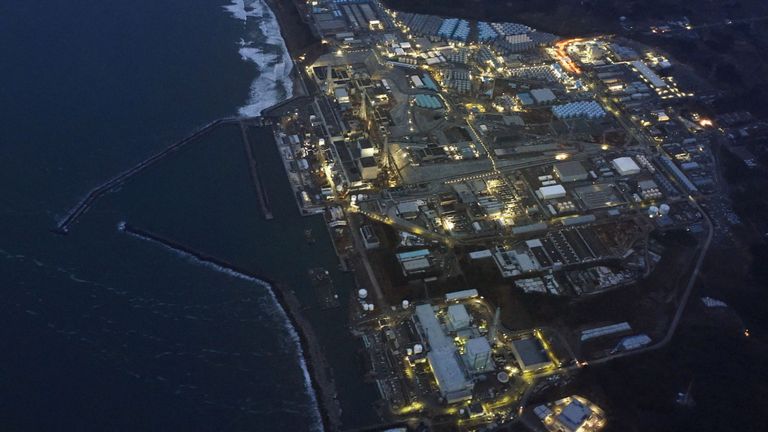 La centrale nucléaire de Fukushima Daiichi, paralysée par le tsunami, est illuminée pour une opération de déclassement à la tombée de la nuit dans la ville d'Okuma, préfecture de Fukushima, au Japon, dans cette photo aérienne prise le 10 mars 2016, un jour avant le cinquième anniversaire du 11 mars 2011. tremblement de terre et tsunami. 