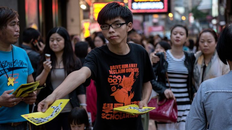 Le 16 novembre 2014, Joshua Wong (C), dirigeant étudiant de Hong Kong, distribue des tracts en soutien aux manifestations pour la démocratie en faveur de la démocratie dans la région de Causeway Bay à Hong Kong
